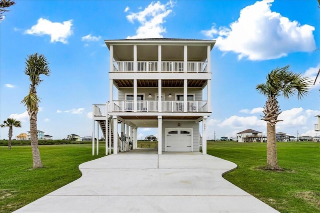 beach home featuring a carport, a garage, and a front lawn