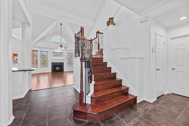 stairway with high vaulted ceiling and ceiling fan