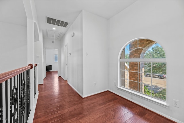 hall featuring plenty of natural light and dark hardwood / wood-style floors