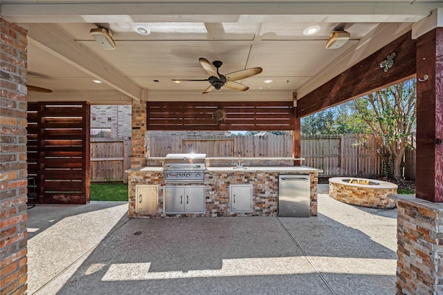 view of patio with sink, area for grilling, ceiling fan, exterior kitchen, and a fire pit