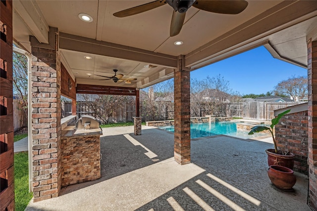 view of patio / terrace with exterior kitchen, pool water feature, a fenced in pool, and ceiling fan