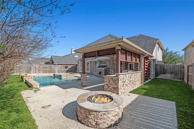 back of house featuring a fenced in pool, a fire pit, a lawn, an outdoor bar, and a patio area