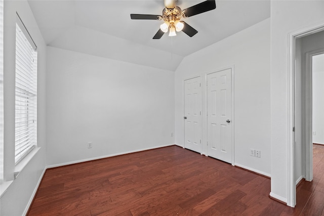 unfurnished bedroom with ceiling fan, dark hardwood / wood-style floors, and vaulted ceiling