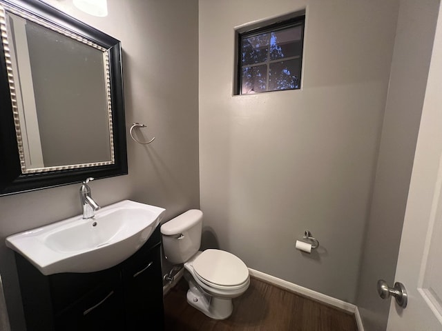 bathroom with hardwood / wood-style floors, vanity, and toilet