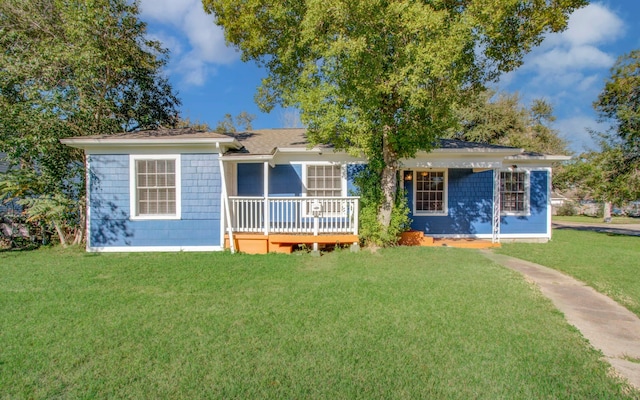 ranch-style home with a wooden deck and a front lawn