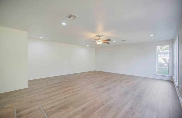 spare room with ceiling fan and light wood-type flooring