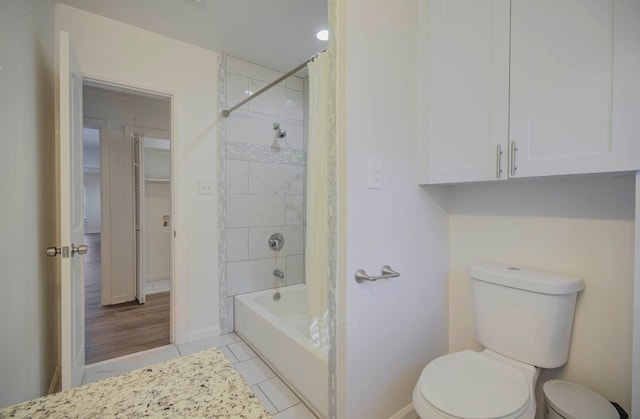 bathroom featuring tile patterned flooring, shower / bath combination with curtain, and toilet