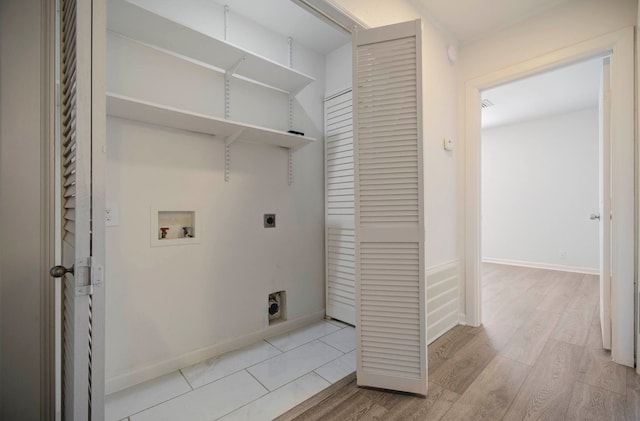 clothes washing area featuring electric dryer hookup, hookup for a washing machine, and light hardwood / wood-style flooring