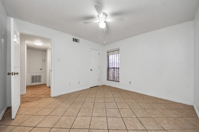 tiled empty room with a textured ceiling and ceiling fan