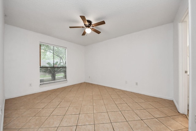 tiled spare room featuring a textured ceiling and ceiling fan