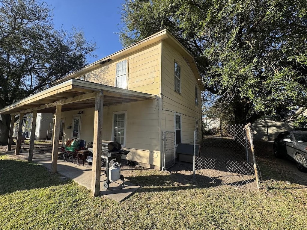 rear view of property featuring a patio area and a yard