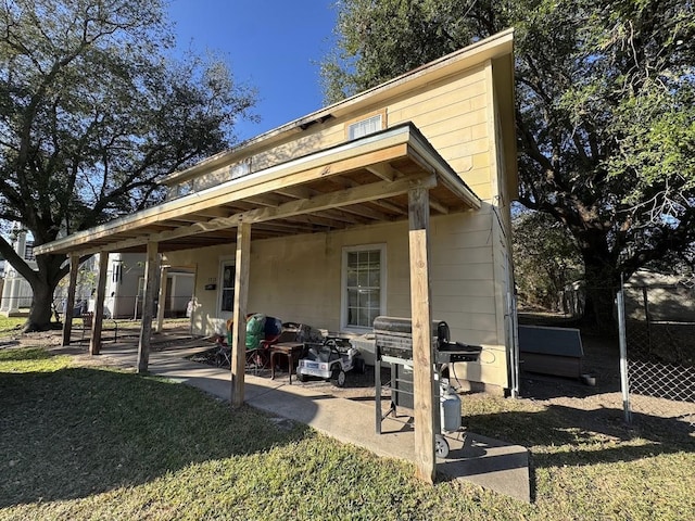 rear view of property with a patio and a lawn