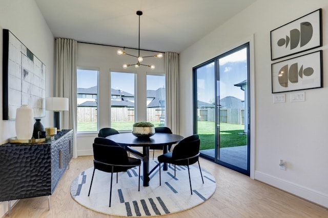 dining space with a notable chandelier and light hardwood / wood-style flooring