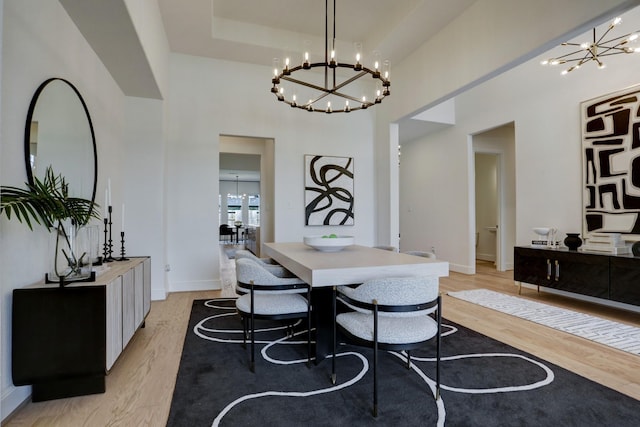 dining area featuring a notable chandelier and light wood-type flooring