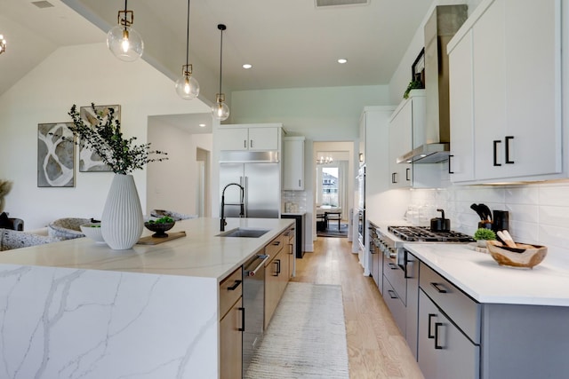 kitchen featuring light stone counters, stainless steel appliances, a spacious island, white cabinets, and hanging light fixtures