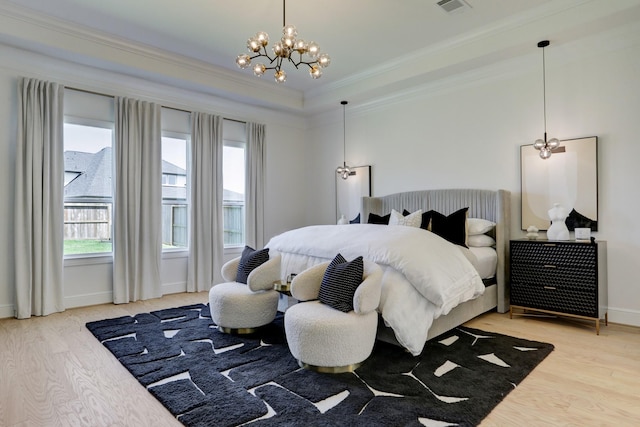 bedroom with hardwood / wood-style floors, ornamental molding, and a notable chandelier