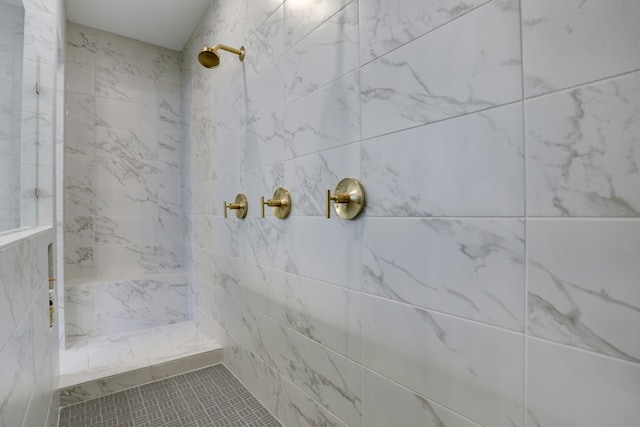 bathroom with a tile shower and tile patterned floors