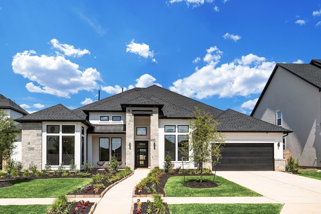 prairie-style home with a garage and a front lawn