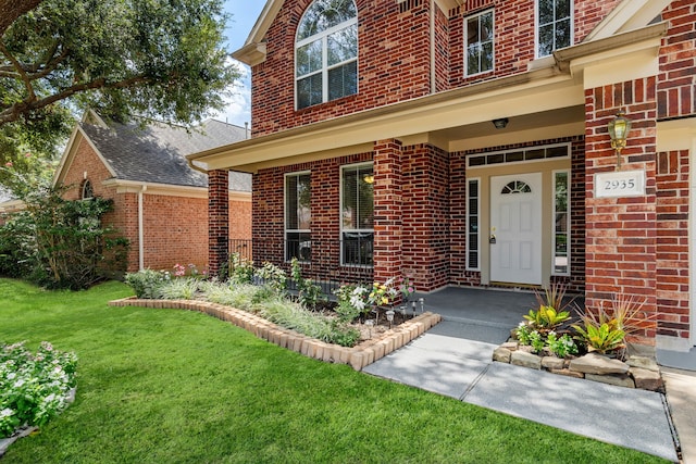 doorway to property with a porch and a lawn