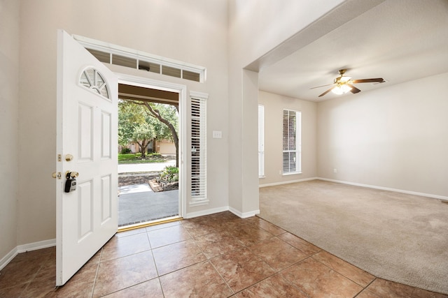 carpeted foyer with ceiling fan