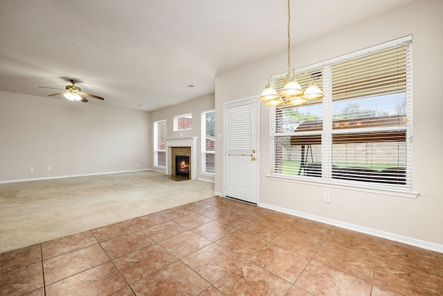 interior space featuring carpet and ceiling fan with notable chandelier