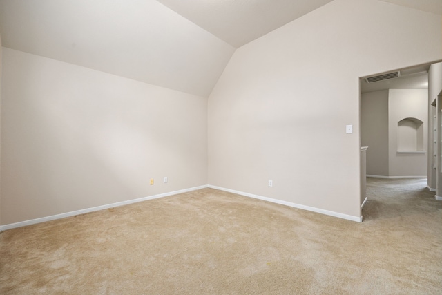 carpeted empty room featuring vaulted ceiling