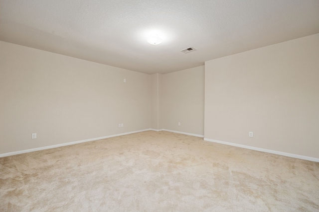 carpeted empty room featuring a textured ceiling