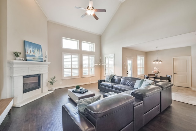 living room with dark hardwood / wood-style floors, ceiling fan, and high vaulted ceiling