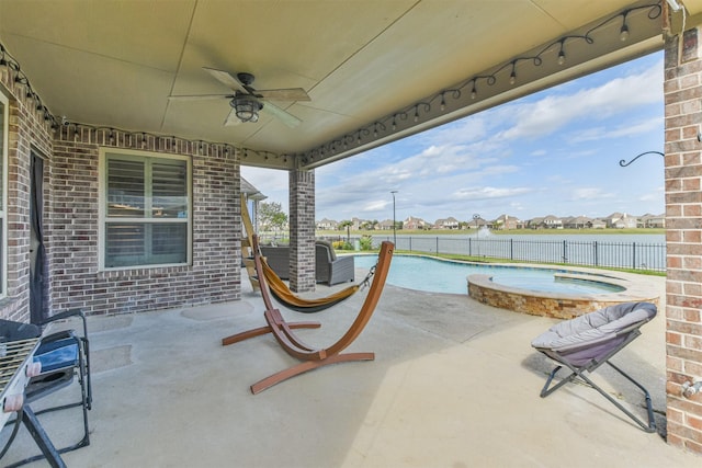 view of patio with ceiling fan and a pool with hot tub