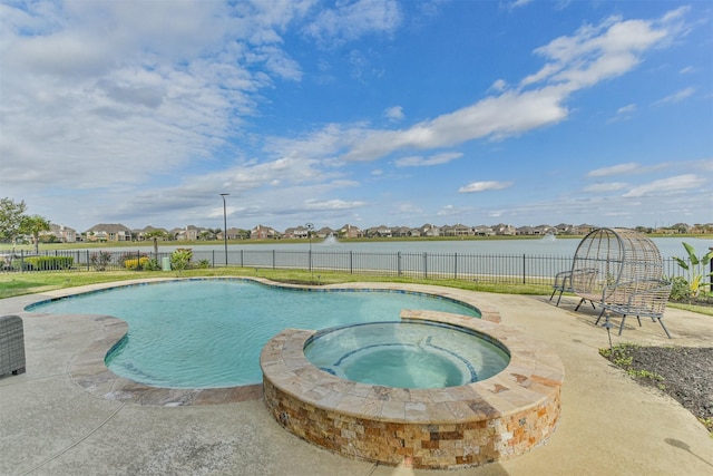 view of swimming pool featuring an in ground hot tub and a water view