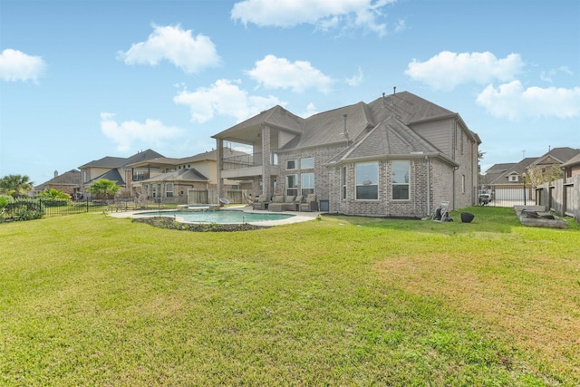 back of property with a lawn and a fenced in pool