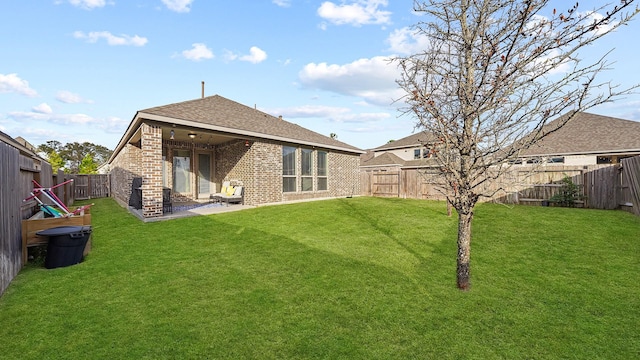 rear view of house featuring a patio area and a yard