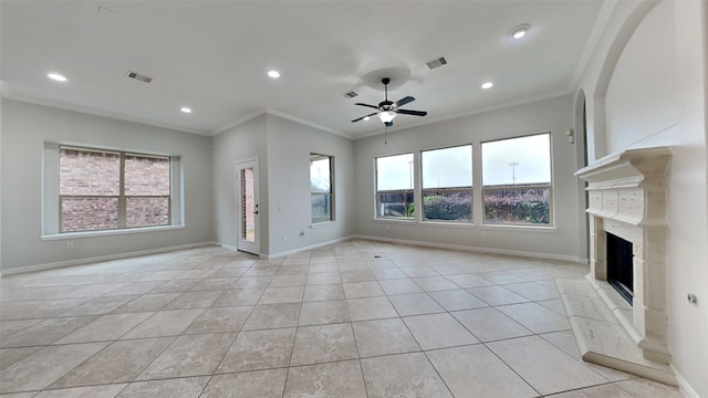 unfurnished living room with a wealth of natural light, a fireplace, ceiling fan, and ornamental molding