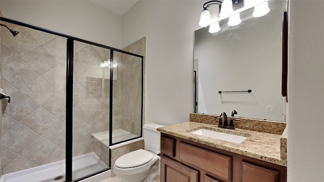 bathroom featuring vanity, toilet, and a shower with door