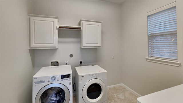 washroom featuring cabinets, washing machine and dryer, and light tile patterned flooring