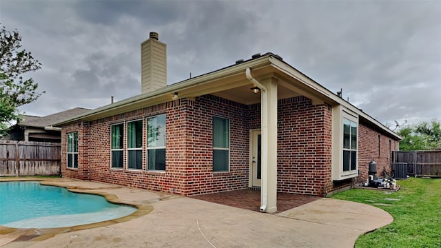 back of house with a fenced in pool, central AC, and a patio area