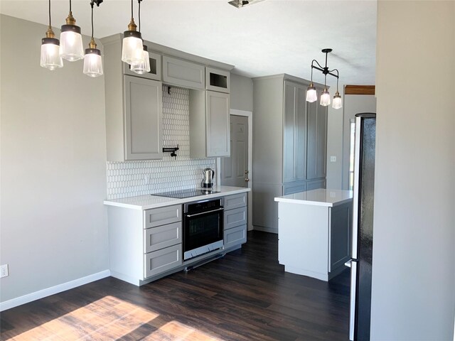 kitchen with decorative backsplash, pendant lighting, dark hardwood / wood-style flooring, and stainless steel appliances