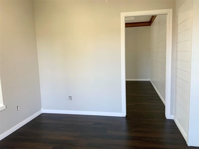 unfurnished room with dark wood-type flooring