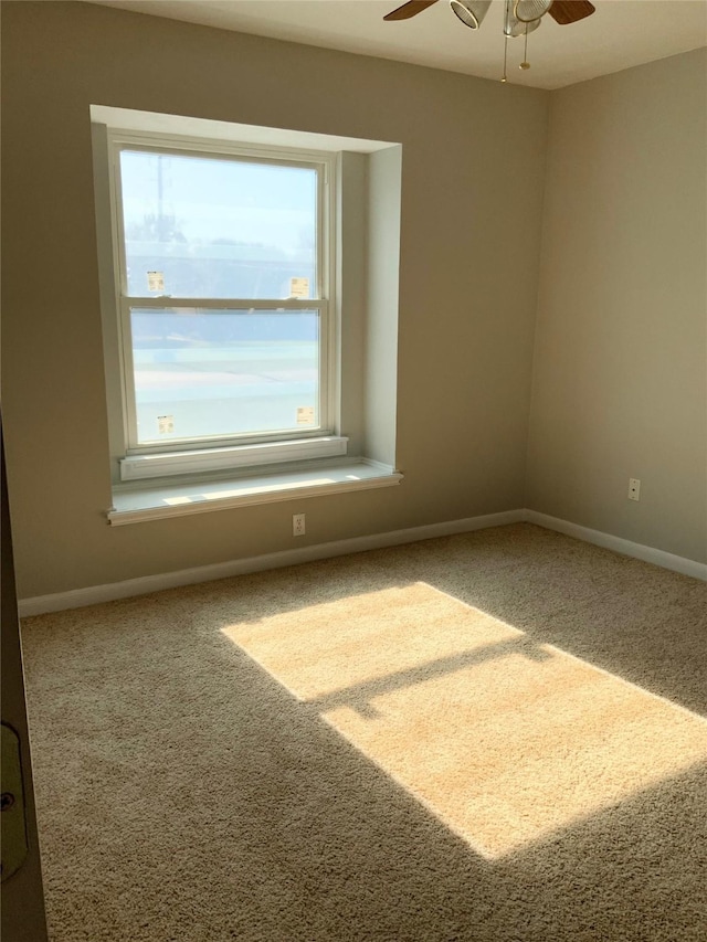 carpeted spare room featuring ceiling fan