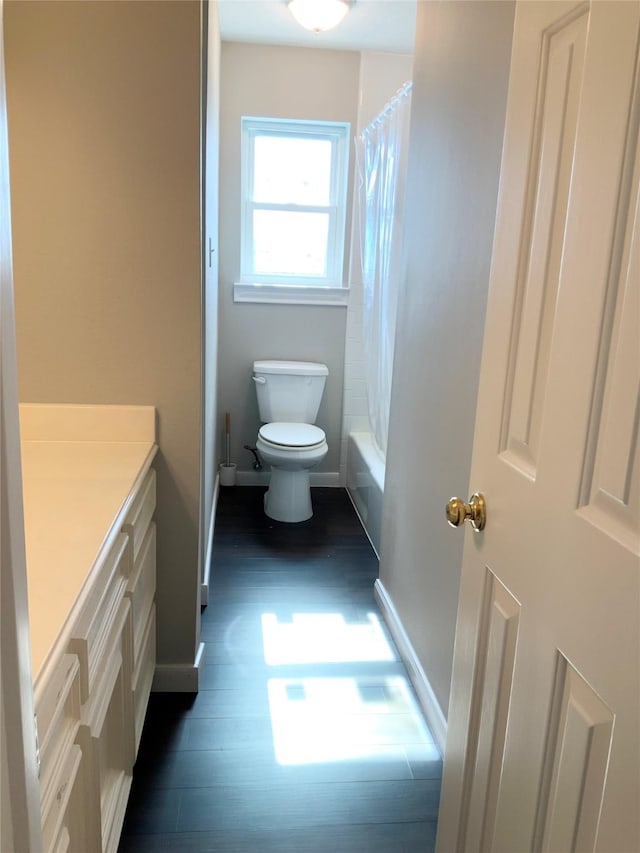 full bathroom with hardwood / wood-style flooring, vanity, toilet, and shower / bathtub combination with curtain