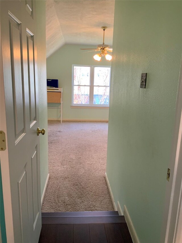 hall featuring carpet flooring and lofted ceiling