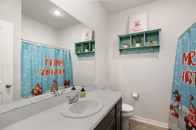 bathroom with a shower with curtain, hardwood / wood-style floors, vanity, and toilet