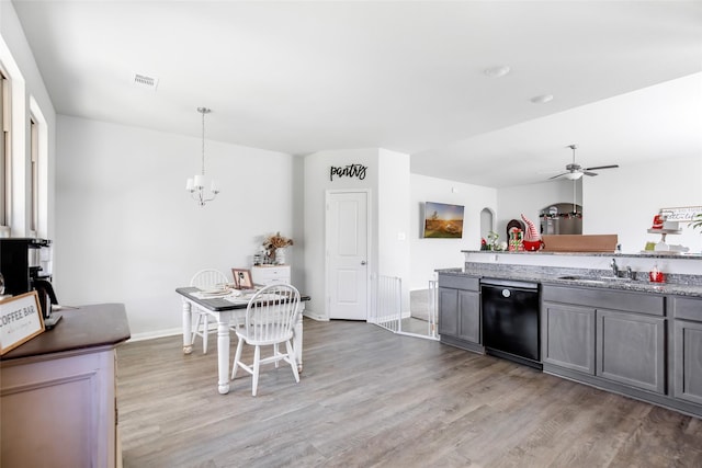 kitchen with dishwasher, hardwood / wood-style floors, ceiling fan with notable chandelier, and hanging light fixtures