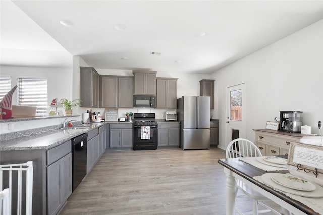 kitchen featuring gray cabinets, sink, black appliances, and light hardwood / wood-style floors