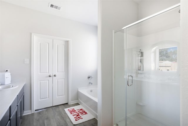 bathroom featuring vanity, hardwood / wood-style flooring, and separate shower and tub