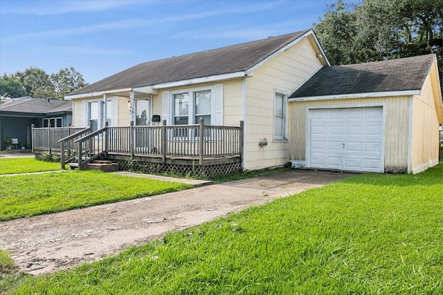 view of front of home featuring a front yard, a garage, and a wooden deck