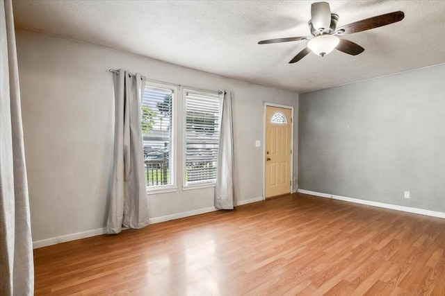 foyer with ceiling fan, light hardwood / wood-style floors, and a textured ceiling