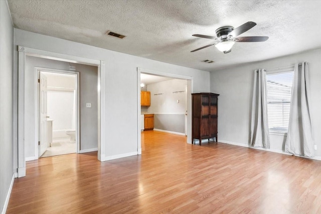 unfurnished living room with ceiling fan, light hardwood / wood-style floors, and a textured ceiling