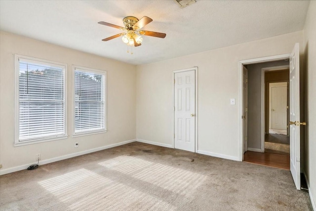 spare room featuring a textured ceiling, light colored carpet, and ceiling fan