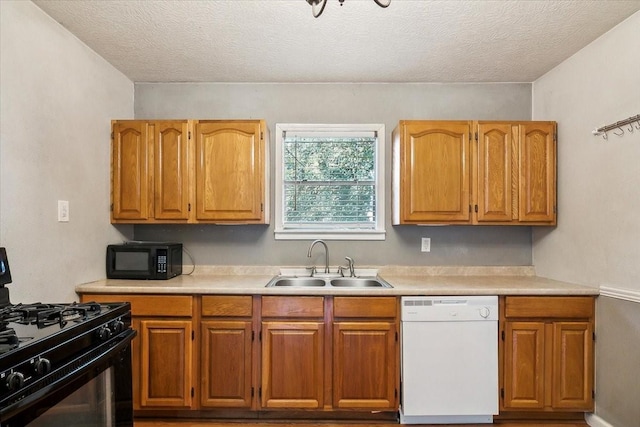 kitchen featuring a textured ceiling, sink, and black appliances